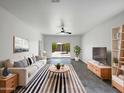 Bright living room features tile floors, a ceiling fan, and sliding glass doors to the backyard at 35337 W San Alvarez Ave, Maricopa, AZ 85138