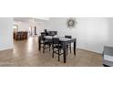 Inviting dining space with tiled flooring and backyard access, adjacent to a kitchen island with bar seating at 3709 W Grovers Ave, Glendale, AZ 85308