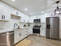 Modern kitchen featuring white cabinets, stainless steel appliances, and wood-look flooring at 5124 N 31St Pl # 522, Phoenix, AZ 85016
