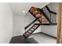 Staircase with black railings and wood steps in a brightly lit area at 5621 N 79Th St, Scottsdale, AZ 85250