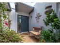 Inviting front entry featuring a dark blue door, bench seating, and mature greenery at 6206 E Avalon Dr, Scottsdale, AZ 85251