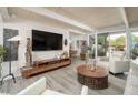 Bright and airy living room with wood-look floors, white leather furniture, and sliding glass doors at 6206 E Avalon Dr, Scottsdale, AZ 85251