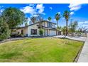 Beautiful two-story home with lush green lawn, mature trees, and a cozy covered patio at 7949 W Pershing Ave, Peoria, AZ 85381