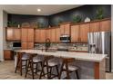 Stylish kitchen with ample cabinetry, granite countertops, stainless steel appliances, and a breakfast bar with seating at 8544 W Mary Ann Dr, Peoria, AZ 85382