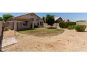 A tranquil backyard features a covered patio, small grassy area, desert landscaping and mature shrubbery at 8614 W Shaw Butte Dr, Peoria, AZ 85345