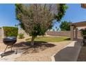 The private backyard has a mature tree and barbecue grill perfect for entertaining at 8614 W Shaw Butte Dr, Peoria, AZ 85345