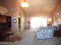 Cozy living room featuring carpeted floors, neutral walls, and lots of natural light at 9203 W Behrend Dr, Peoria, AZ 85382