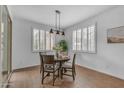 Inviting dining room with wood floors, modern lighting, and shuttered windows at 9853 E Solstice Ave, Mesa, AZ 85212
