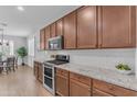 Well-lit kitchen with stainless steel appliances, granite countertops, and ample cabinet space at 9853 E Solstice Ave, Mesa, AZ 85212