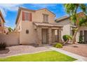 Two-story home featuring stone accents and a tiled roof, complemented by low-water landscaping at 10 N 87Th Dr, Tolleson, AZ 85353