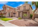 Two-story home showcasing stone accents and low-water landscaping; part of a neighborhood at 10 N 87Th Dr, Tolleson, AZ 85353