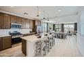 Open-concept kitchen featuring a large island with seating and pendant lighting, connecting to the dining and living spaces at 10049 E Ulysses Ave, Mesa, AZ 85212