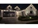 Gorgeous new construction home exterior at night features white paint and a two-car garage at 10156 E Talon Ave, Mesa, AZ 85212