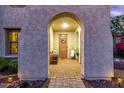 Inviting covered porch with charming decor, arched entryway, and cozy bench seating at 11844 W Nadine Way, Peoria, AZ 85383