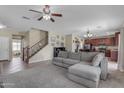 Inviting open-concept living room featuring staircase, ceiling fan, and carpeted floors at 1237 W Agrarian Hills Dr, San Tan Valley, AZ 85143