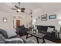 Comfortable living room featuring plush sofas, a ceiling fan, and hardwood floors at 150 N Nielson St, Gilbert, AZ 85234