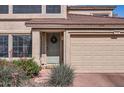 Charming entrance with a gray front door, desert landscaping, and a two-car garage at 15550 N Frank Lloyd Wright Blvd # 1101, Scottsdale, AZ 85260