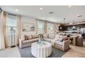 Bright, modern living room with a large sectional sofa, neutral tones, and open concept design at 15791 W Kendall St, Goodyear, AZ 85338