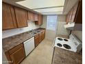 Functional kitchen with ample cabinet space, white appliances, and a bright, windowed view at 16602 N 25Th St # 217, Phoenix, AZ 85032