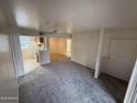 Spacious living room featuring new carpeting, a ceiling fan, and easy access to the kitchen at 16602 N 25Th St # 217, Phoenix, AZ 85032