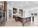 A modern kitchen features a large island, stainless steel appliances, and plenty of counter space at 18883 E Celtic Manor Dr, Queen Creek, AZ 85142