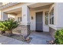 Inviting covered front porch with stone accents, security door, and desert landscaping at 19323 E Canary Way, Queen Creek, AZ 85142