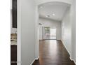 Bright hallway features wood-look tile flooring, neutral paint, and an open archway leading to the living area at 21533 N Greenway Rd, Maricopa, AZ 85138