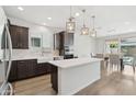 Open-concept kitchen and dining area with stainless appliances, modern lighting, and wood-look flooring at 22023 N 28Th Pl, Phoenix, AZ 85050