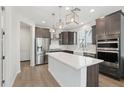 Bright kitchen features stainless appliances, island with white countertop, and modern pendant lighting at 22023 N 28Th Pl, Phoenix, AZ 85050