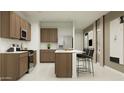 Bright kitchen featuring an island with barstool seating, quartz countertops, and stainless steel appliances at 23207 W Marguerite Ave, Buckeye, AZ 85326