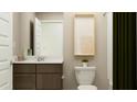 Bathroom featuring a wood vanity, a white countertop, a toilet, and a neutral shower curtain at 23372 W Sonrisas St, Buckeye, AZ 85326