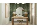 Home office with desk, chair, a stylish mirror, lamps, and chic wallpaper at 23372 W Sonrisas St, Buckeye, AZ 85326