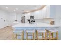 Modern kitchen boasts white cabinets, stainless steel appliances, an island, and stylish bar stool seating at 2511 W Queen Creek Rd # 374, Chandler, AZ 85248