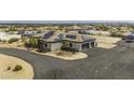 Aerial view of the home with solar panels, desert landscaping, RV parking and circular drive at 2751 N Ralston Rd, Maricopa, AZ 85139