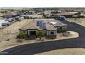 Aerial view of a single-story home with a circular drive, solar panels and RV parking area at 2751 N Ralston Rd, Maricopa, AZ 85139