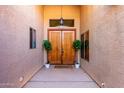 Inviting entryway featuring double doors, decorative plants, and a stylish overhead light fixture at 29506 N 21St Ave, Phoenix, AZ 85085