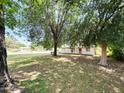 A cozy home with a white picket fence and front porch, surrounded by mature trees and greenery at 3215 W Orangewood Ave, Phoenix, AZ 85051