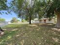 A cozy home with a white picket fence and front porch, surrounded by mature trees and greenery at 3215 W Orangewood Ave, Phoenix, AZ 85051