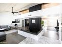 Spacious living room with modern fireplace, concrete floors, and wooden plank ceiling at 4317 E Ludlow Dr, Phoenix, AZ 85032