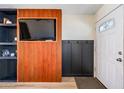 Inviting entryway featuring stylish wood paneling with built-in shelving and a coat rack at 4828 N 71St Ave, Phoenix, AZ 85033