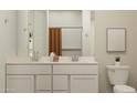 Bright bathroom featuring a double vanity with modern fixtures and a neutral color palette at 4987 S 233Rd Dr, Buckeye, AZ 85326