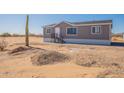 Charming single-story home featuring a desert landscape, large windows, and a well-maintained exterior at 54073 W Stallion Rd, Maricopa, AZ 85139