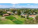 Scenic aerial view of a lush green golf course surrounded by residential homes, with a backdrop of mountains at 633 Leisure World --, Mesa, AZ 85206