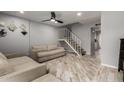 Inviting living room featuring wood floors, neutral walls, a cozy sofa, and staircase at 6348 N 7Th Ave # 6, Phoenix, AZ 85013