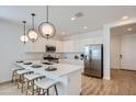 Modern kitchen with white cabinets, stainless steel appliances, quartz countertops, and pendant lighting at 8154 E Petra Ave, Mesa, AZ 85212