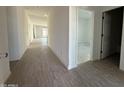 Bright hallway featuring modern wood-style tile flooring leading to various rooms at 9536 W Parkway Dr, Tolleson, AZ 85353