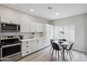 Clean kitchen with white cabinets, stainless steel appliances, and an adjacent dining area with natural light at 9600 N 96 Th St # 130, Scottsdale, AZ 85258