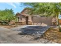 Inviting single-story home boasting a two-car garage, desert landscaping, and mature shade trees at 9630 W Atlantis Way, Tolleson, AZ 85353