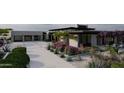 Wide driveway leading to a modern home and a garage with glass doors surrounded by lush landscaping at 0 N 128Th St, Scottsdale, AZ 85255