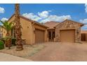 A two car garage with stone and stucco exterior and brick paved driveway at 1022 W Calypso Ct, Gilbert, AZ 85233